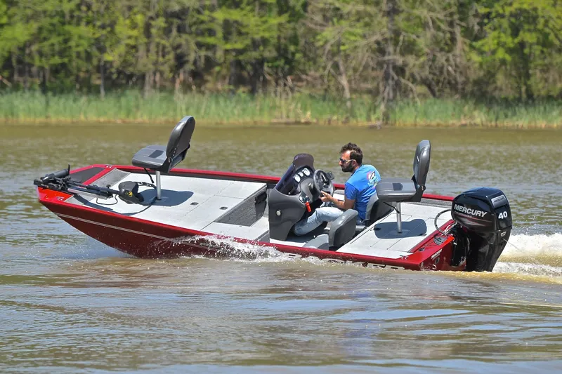 Slide: The Image of 2019 Bass Tracker Pro 170 boat on a lake, with a person driving. - 6
