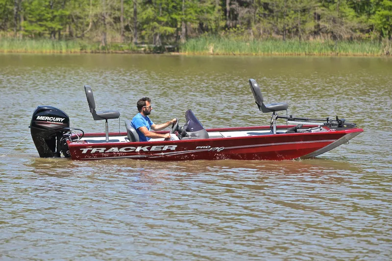 Slide: The Image of 2019 Bass Tracker Pro 170 boat on a lake, featuring a Mercury engine. - 7