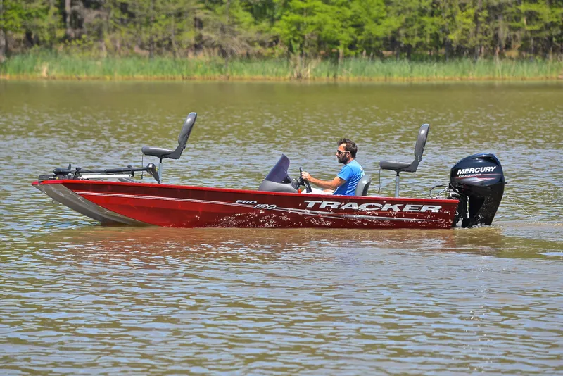 Slide: The Image of 2019 Bass Tracker Pro 170 boat on a lake with a person driving. - 9
