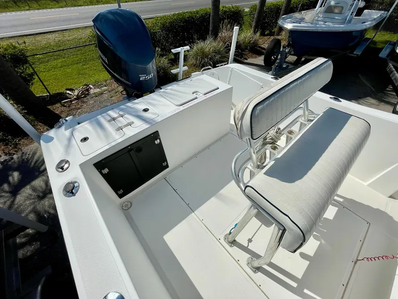 Slide: The Image of 2002 Seastrike 240 boat interior with seating and motor, parked outdoors. - 13