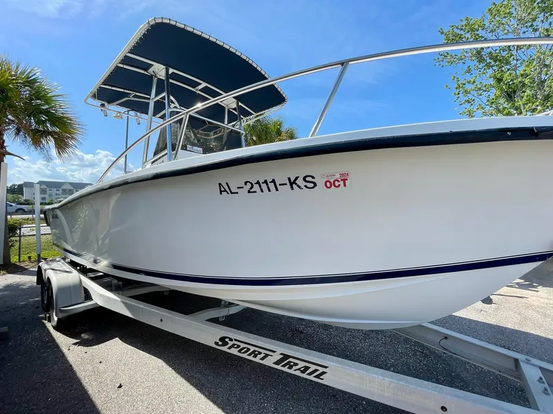 Slide: The Image of 2002 Seastrike 240 boat on Sport Trail trailer, parked outdoors under clear blue sky. - 2