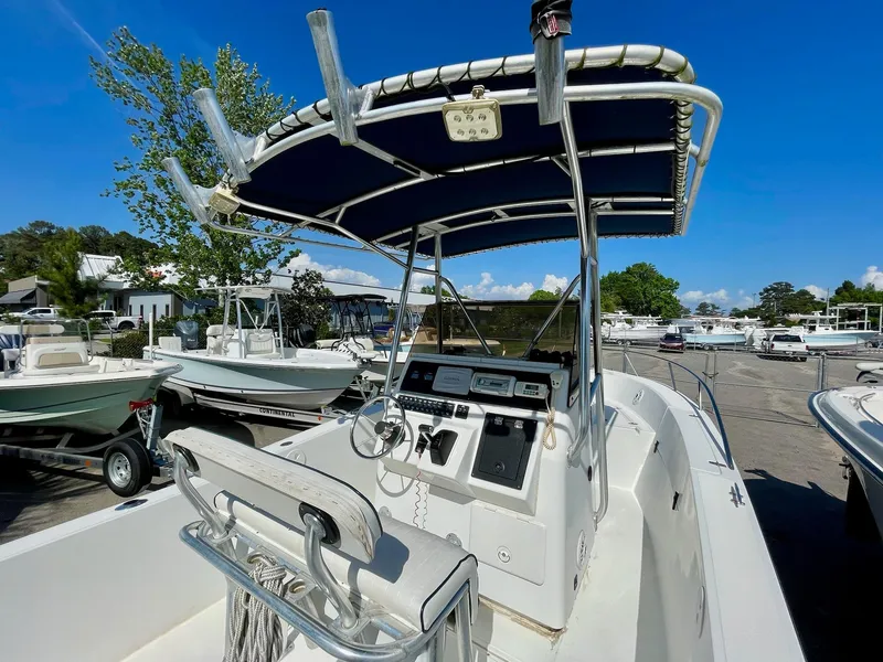 Slide: The Image of 2002 Seastrike 240 boat with center console and canopy, docked in a marina under clear blue sky. - 9