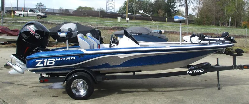Slide: The Image of 2025 Nitro Z18 boat on trailer, blue and white design, parked outdoors. - 5