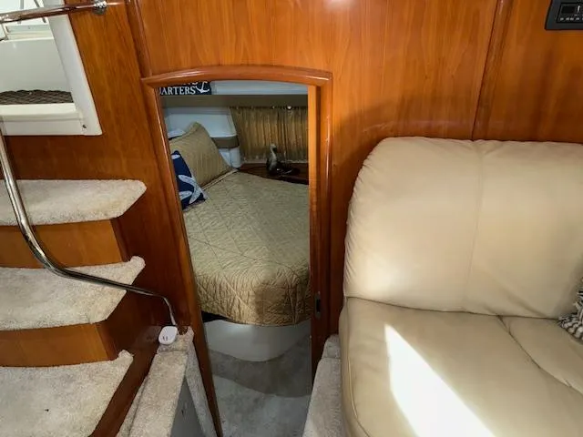 Slide: The Image of 2006 Carver 36 Motor Yacht interior with stairs, cozy bedroom, and beige seating. - 35