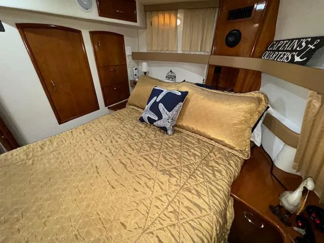 Slide: The Image of Luxurious bedroom in 2006 Carver 36 Motor Yacht with gold bedding and nautical decor. - 38