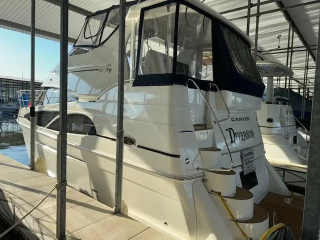 Slide: The Image of 2006 Carver 36 Motor Yacht docked under a covered marina, featuring sleek design and spacious deck. - 5
