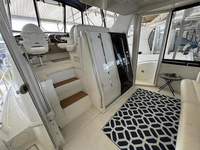 Slide: The Image of 2006 Carver 36 Motor Yacht interior with seating, stairs, and geometric rug. - 6