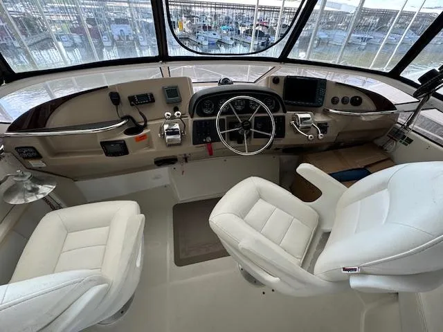 Slide: The Image of 2006 Carver 36 Motor Yacht helm with dual white captain chairs and navigation controls. - 9