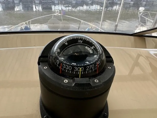 Slide: The Image of Compass on 2006 Carver 36 Motor Yacht dashboard, overlooking marina waters. - 17