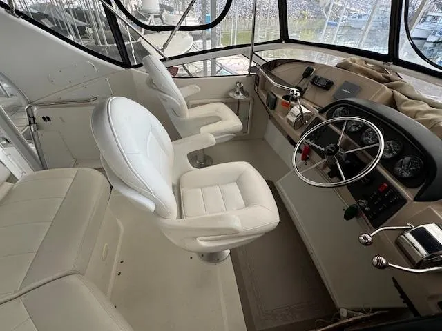 Slide: The Image of 2006 Carver 36 Motor Yacht helm with white seating and navigation controls. - 18