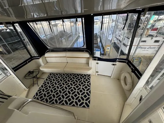 Slide: The Image of 2006 Carver 36 Motor Yacht interior with seating, geometric rug, and marina view. - 22
