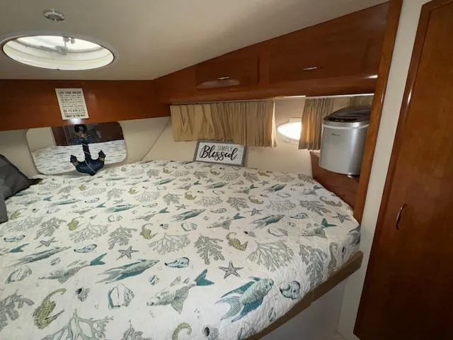 Slide: The Image of Cozy bedroom in 2006 Carver 36 Motor Yacht with nautical-themed bedding and wood cabinetry. - 33