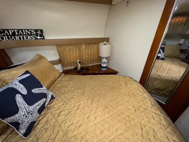 Slide: The Image of 2006 Carver 36 Motor Yacht bedroom with gold bedding, starfish pillow, and nautical decor. - 39