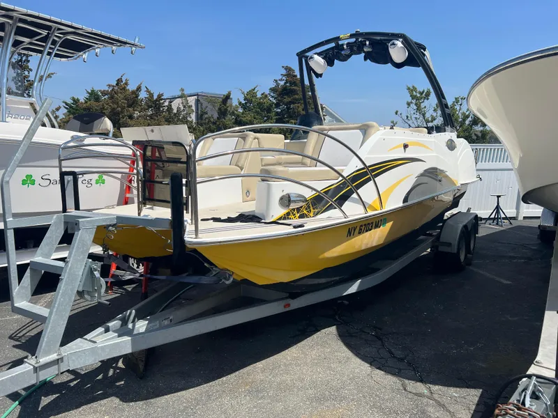 Slide: The Image of 2016 Caravelle RAZOR 238PR boat on trailer, yellow and white design, parked outdoors. - 0