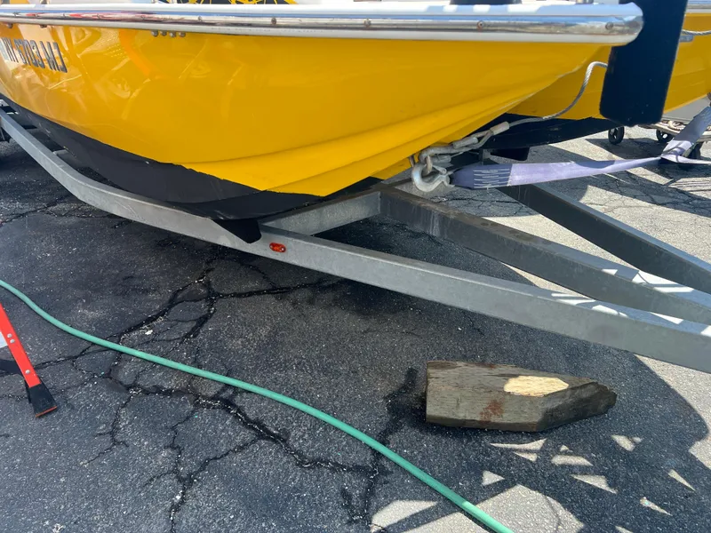 Slide: The Image of Yellow Caravelle RAZOR 238PR boat on trailer, 2016 model, parked on cracked asphalt. - 10