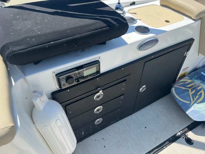 Slide: The Image of 2016 Caravelle RAZOR 238PR boat interior with storage, radio, and seating area. - 7