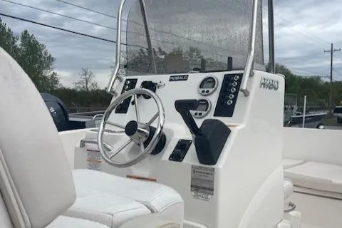 Slide: The Image of 2016 Robalo R180 CC boat console with steering wheel and controls, under cloudy sky. - 5