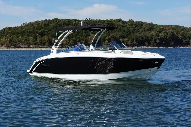Slide: The Image of 2017 Cobalt R7 boat cruising on a lake with forested shoreline. - 0