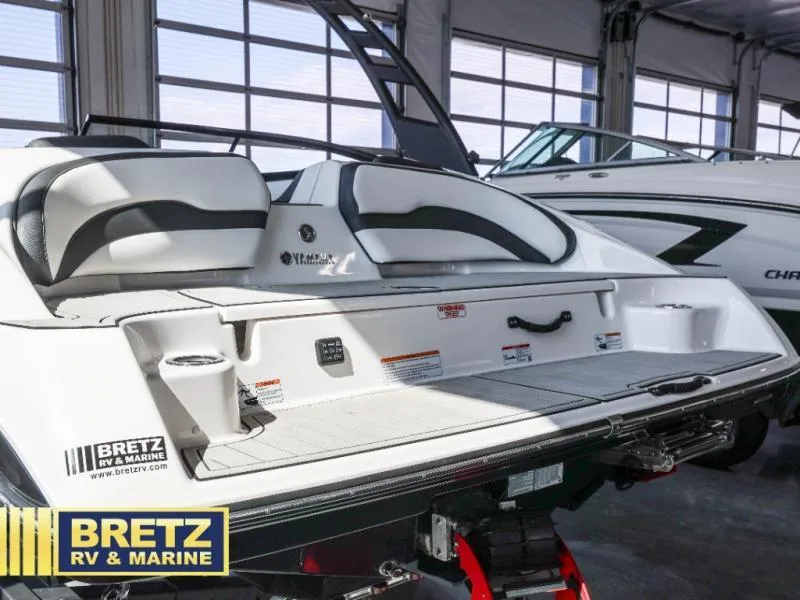 Slide: The Image of 2024 Yamaha boat interior at Bretz RV & Marine showroom, featuring sleek seating and storage. - 23
