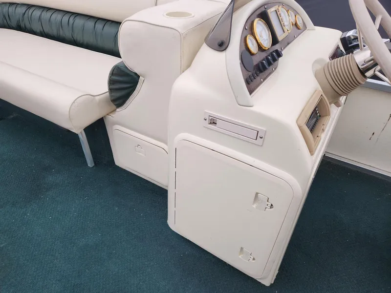 Slide: The Image of 2005 Tahoe Pontoon GRAND TAHOE XRP 23 dashboard and seating area, featuring beige upholstery. - 14