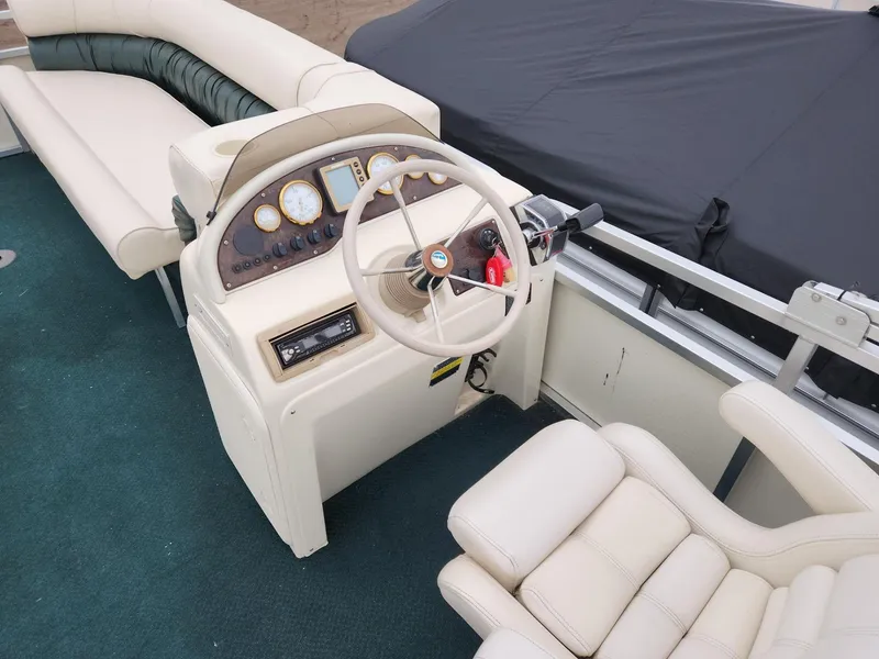 Slide: The Image of 2005 Tahoe Pontoon GRAND TAHOE XRP 23 helm with steering wheel and gauges, featuring plush seating. - 6