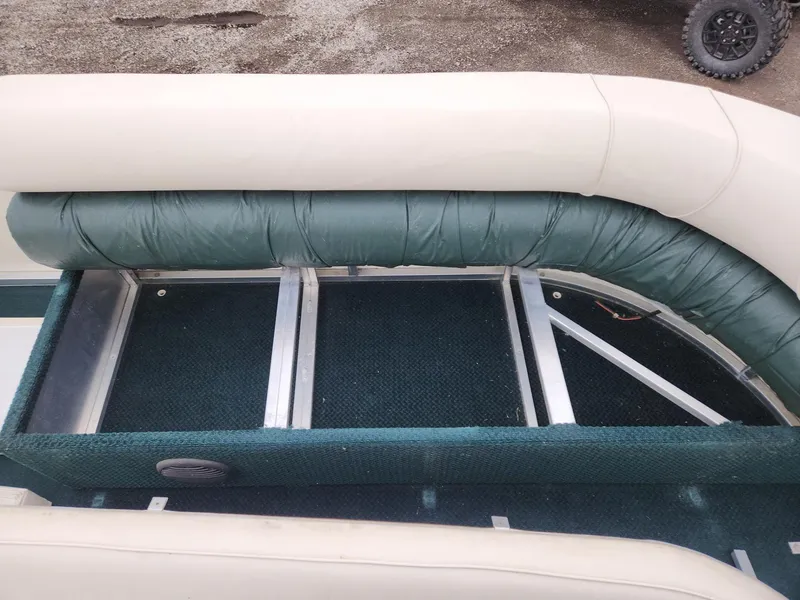Slide: The Image of 2005 Tahoe Pontoon GRAND TAHOE XRP 23 interior seating with green upholstery and storage space. - 7