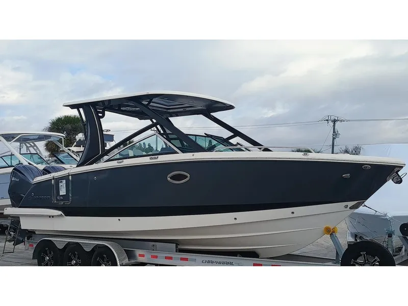 Slide: The Image of 2024 Chaparral 280 OSX boat on trailer, sleek design, dark hull, modern features. - 1