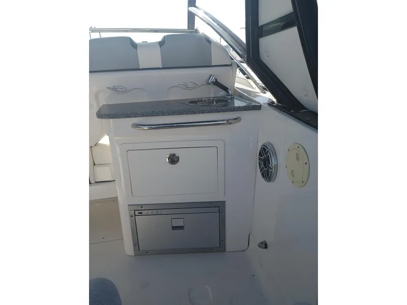 Slide: The Image of 2024 Chaparral 280 OSX boat interior with kitchenette and storage. - 20