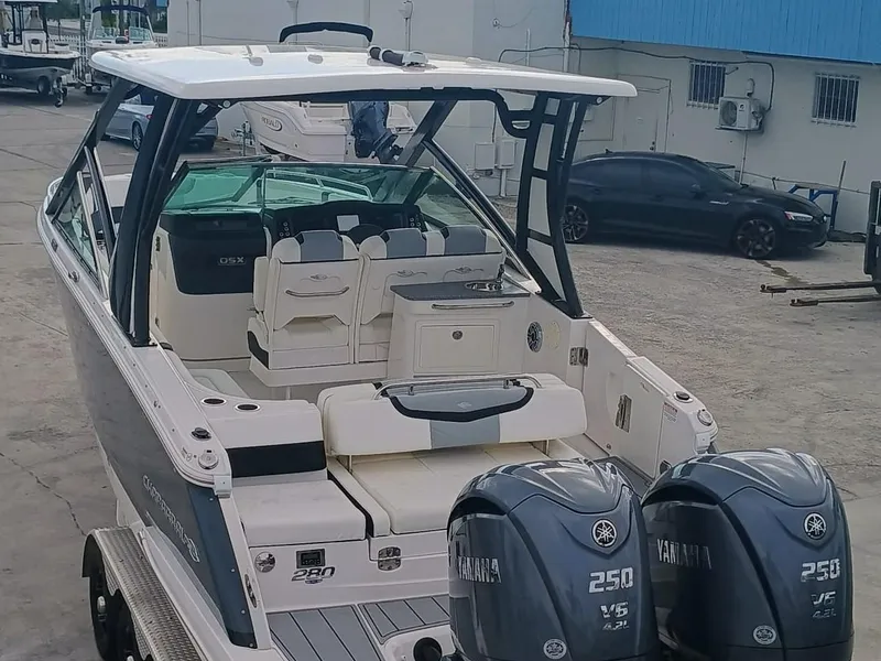 Slide: The Image of 2024 Chaparral 280 OSX boat with dual Yamaha 250 engines, docked in a marina. - 5