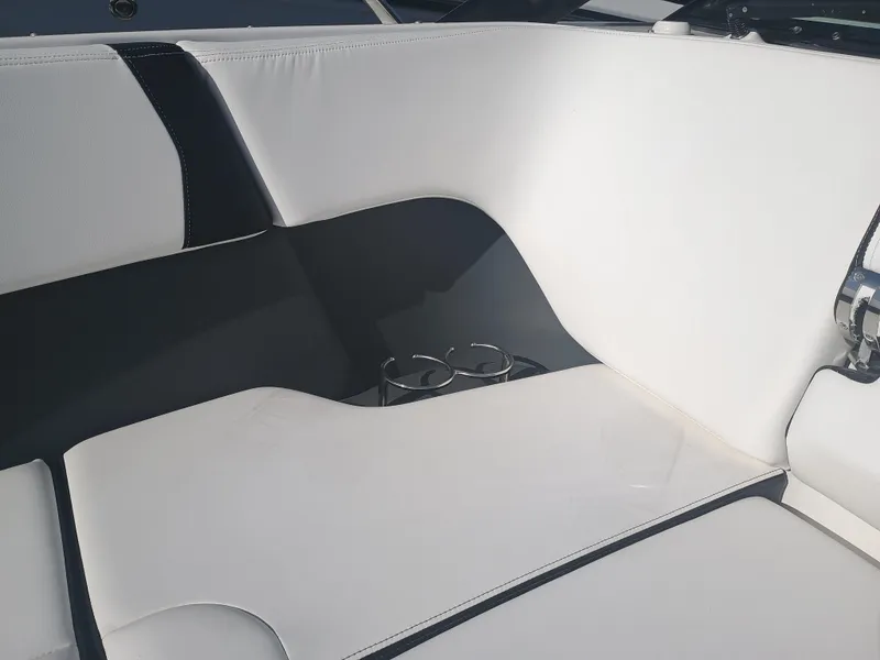 Slide: The Image of 2024 Chaparral 280 OSX boat interior with white and black seating and cup holders. - 8