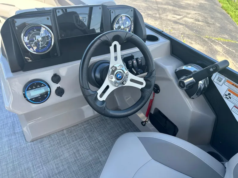 Slide: The Image of 2025 Premier 220 Sunscape RF boat dashboard with steering wheel and controls. - 13