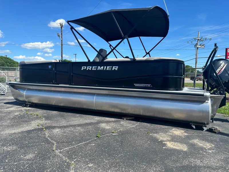 Slide: The Image of 2025 Premier 220 Sunscape RF pontoon boat with canopy, parked on pavement under blue sky. - 4