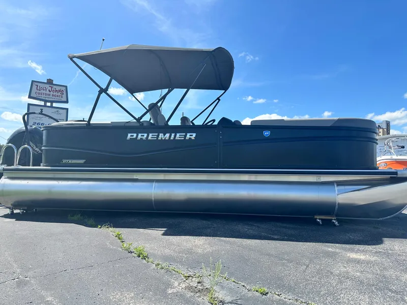 Slide: The Image of 2025 Premier 220 Sunscape RF pontoon boat with canopy on display under blue sky. - 5