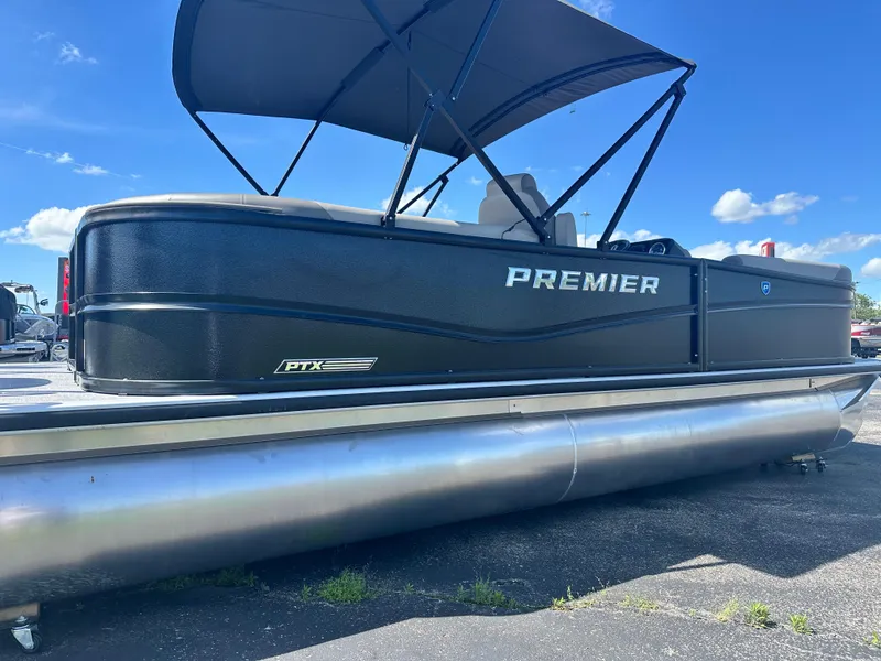 Slide: The Image of 2025 Premier 220 Sunscape RF pontoon boat with canopy, parked on pavement under blue sky. - 7