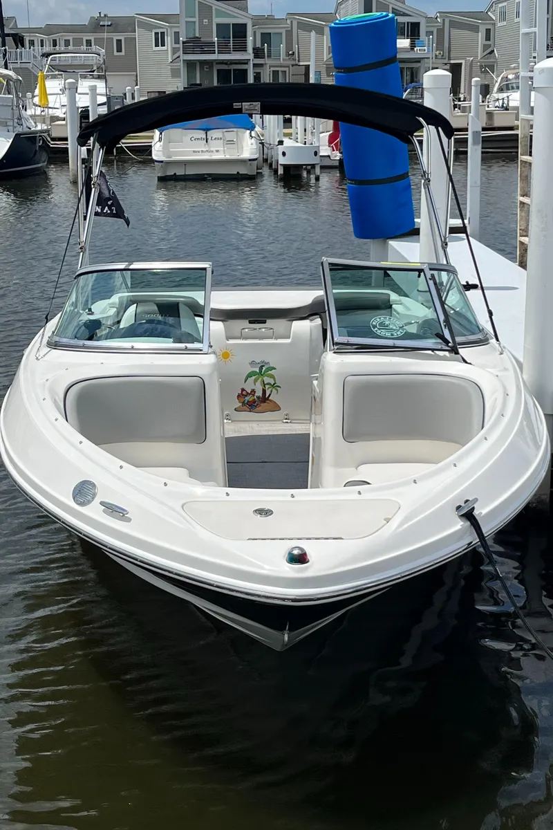 Slide: The Image of 2011 Sea Ray 205 Sport boat docked in marina, featuring open bow and sleek design. - 2