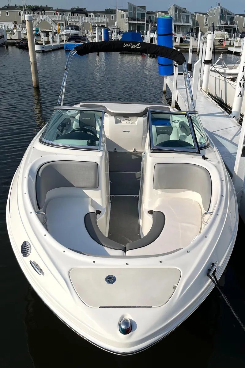 Slide: The Image of 2011 Sea Ray 205 Sport boat docked in marina, featuring sleek design and spacious seating. - 4
