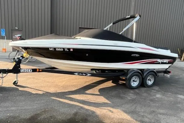 Slide: The Image of 2011 Sea Ray 205 Sport boat on trailer, black and white design, parked outdoors. - 7