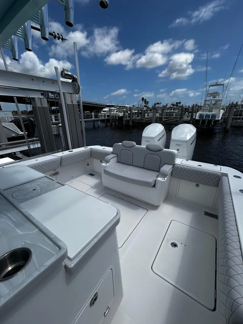Slide: The Image of 2023 HCB 39 Speciale boat interior with seating, docked at marina under blue sky. - 11