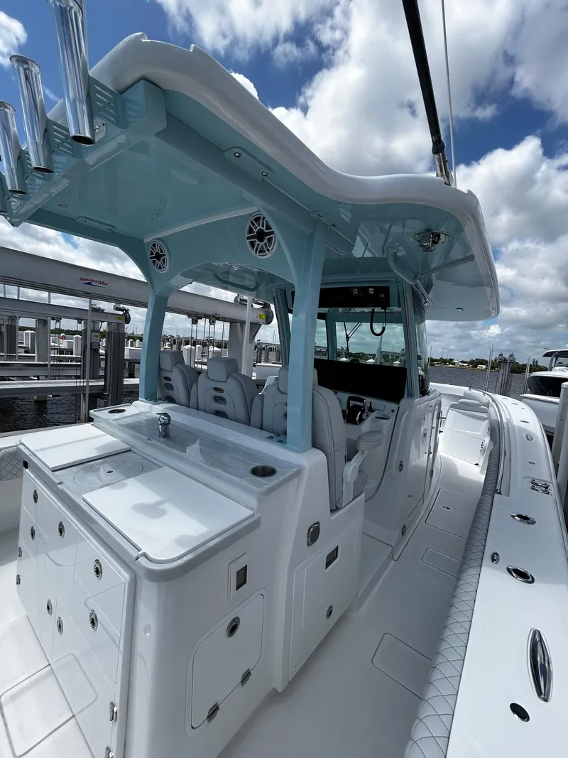 Slide: The Image of 2023 HCB 39 Speciale boat with sleek design and modern features docked under a cloudy sky. - 13