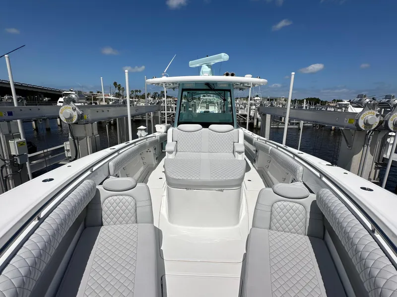Slide: The Image of 2023 HCB 39 Speciale boat with luxurious seating, docked at a marina under a clear sky. - 15