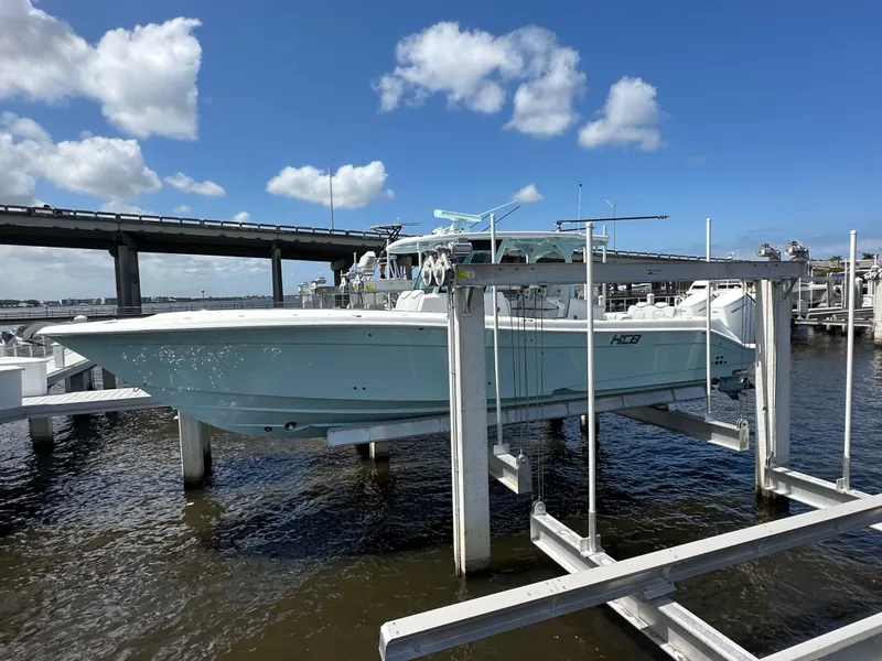 Slide: The Image of 2023 HCB 39 Speciale boat on lift, dockside, under blue sky. - 16