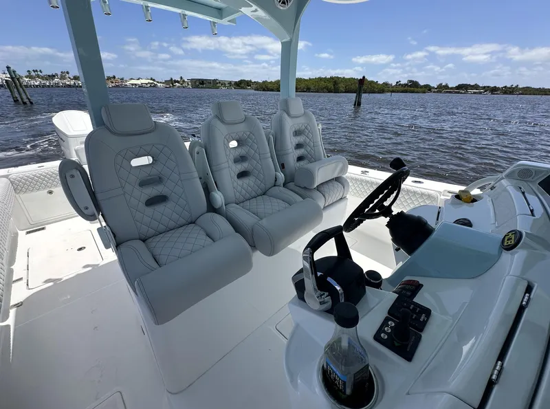 Slide: The Image of 2023 HCB 39 Speciale boat interior with luxury seating and helm, on a sunny day. - 30