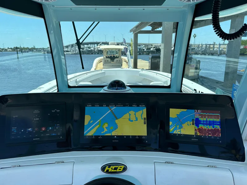 Slide: The Image of Dashboard view of 2023 HCB 39 Speciale boat with navigation screens at a marina. - 5