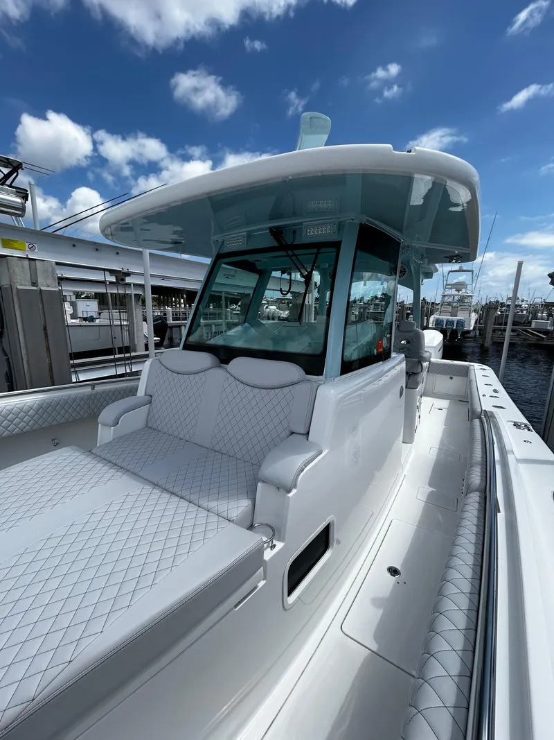 Slide: The Image of 2023 HCB 39 Speciale boat with sleek design, white seating, and modern helm under a blue sky. - 6