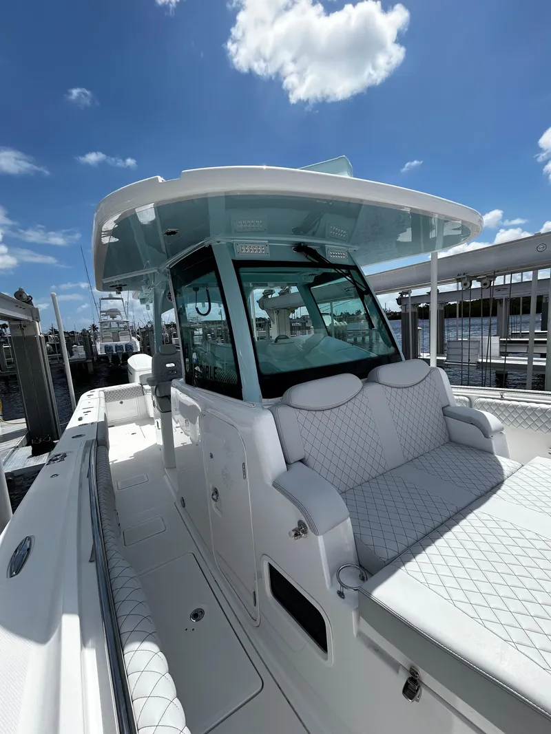 Slide: The Image of 2023 HCB 39 Speciale boat with sleek design, docked under a clear blue sky. - 8