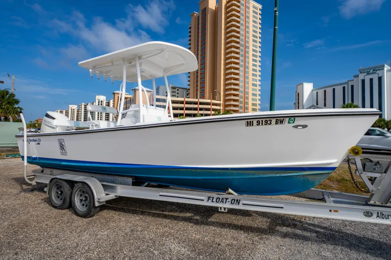 Slide: The Image of 2016 Albury Brothers 23 boat on trailer, urban backdrop, clear sky. - 0