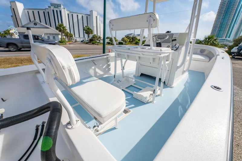 Slide: The Image of 2016 Albury Brothers 23 boat interior with white seating and console, parked near modern buildings. - 16
