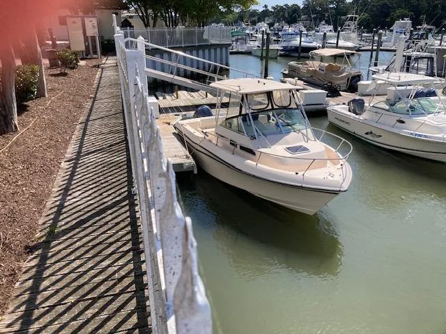 Slide: The Image of 1997 Grady-White 232 Gulfstream boat docked at a marina. - 10