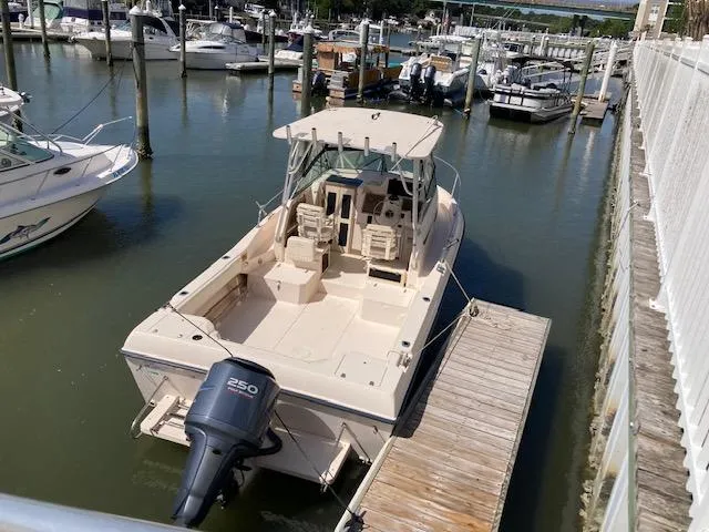 Slide: The Image of 1997 Grady-White 232 Gulfstream boat docked in a marina, featuring a 250 horsepower engine. - 12