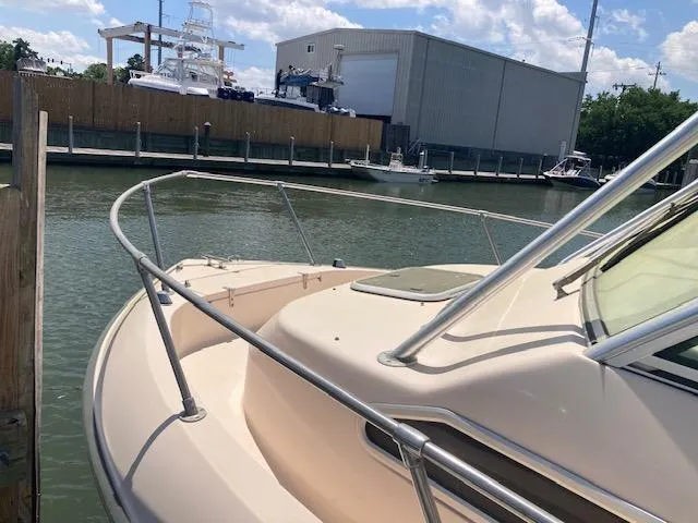Slide: The Image of 1997 Grady-White 232 Gulfstream boat docked at marina under blue sky. - 4
